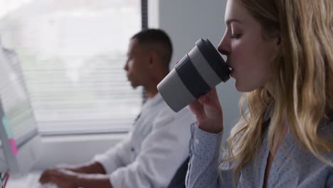 caucasian woman drinking while working