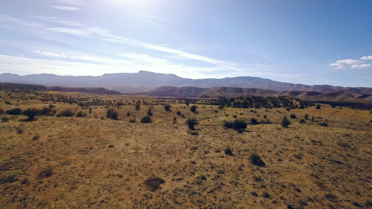 vuelo aéreo sobre terreno abierto hacia una cadena montañosa, sedona, arizona