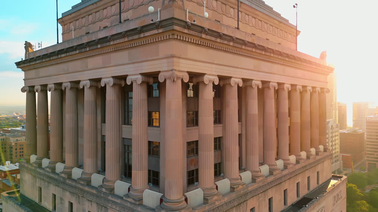 Saint Louis USA, 14 August 2025: Flight around the façade with columns at sunset. Building of St. Louis Civil Courts building, Missouri, USA. The Gateway Arch at backdrop