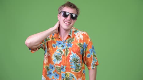 young handsome tourist man having neck pain