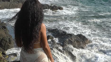 Woman-looking-out-over-coast-of-Costa-Rica-with-crashing-ocean-waves