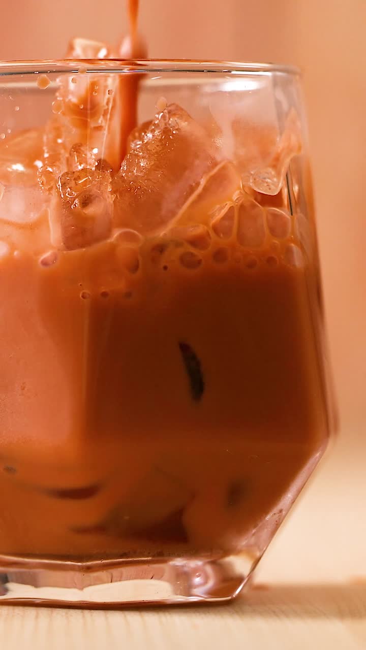 Caffè freddo rinfrescante versato su ghiaccio in un bicchiere