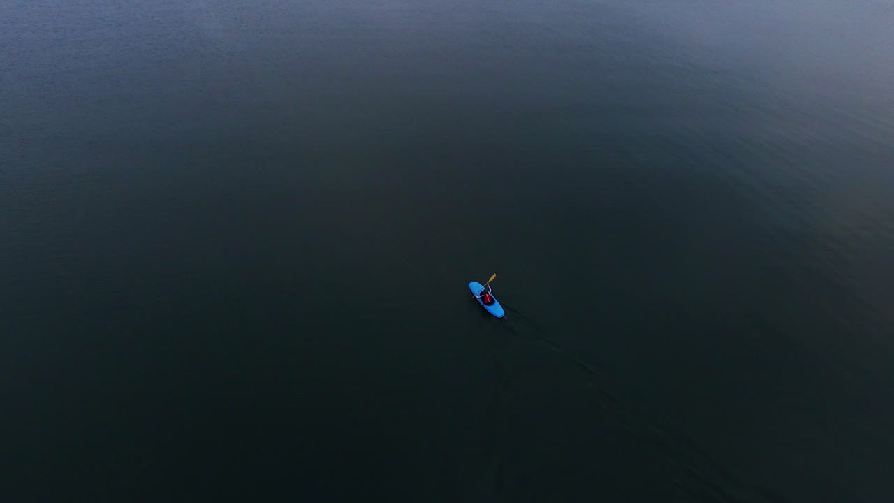 kayak flotando en un mar tranquilo. vista aérea hombre en kayak viajando en el mar