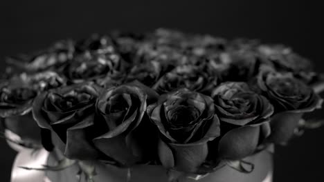 black roses bouquet arrangement spinning with ribbon on black background