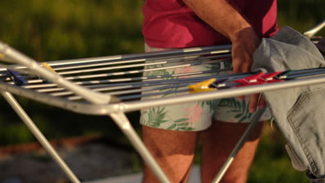 setting up a clothes drying rack in evening light