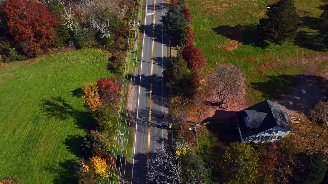 가을에  ⁇ 은 날 주위에 다채로운 나무와 함께 시골 도로 위의 높은 각도의 공중 전망