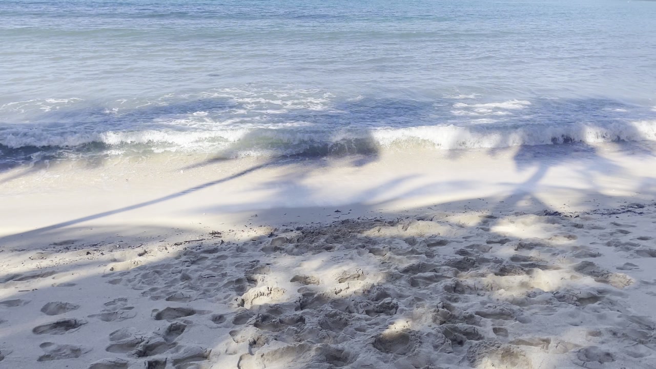 Calming tropical beach waves on white sand shore in peaceful scenic landscape pov meditative summer vibes