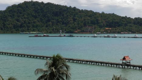 Static-shot-of-2-piers-in-the-ocean,-one-with-red-roofs-and-one-with-boats-CROP