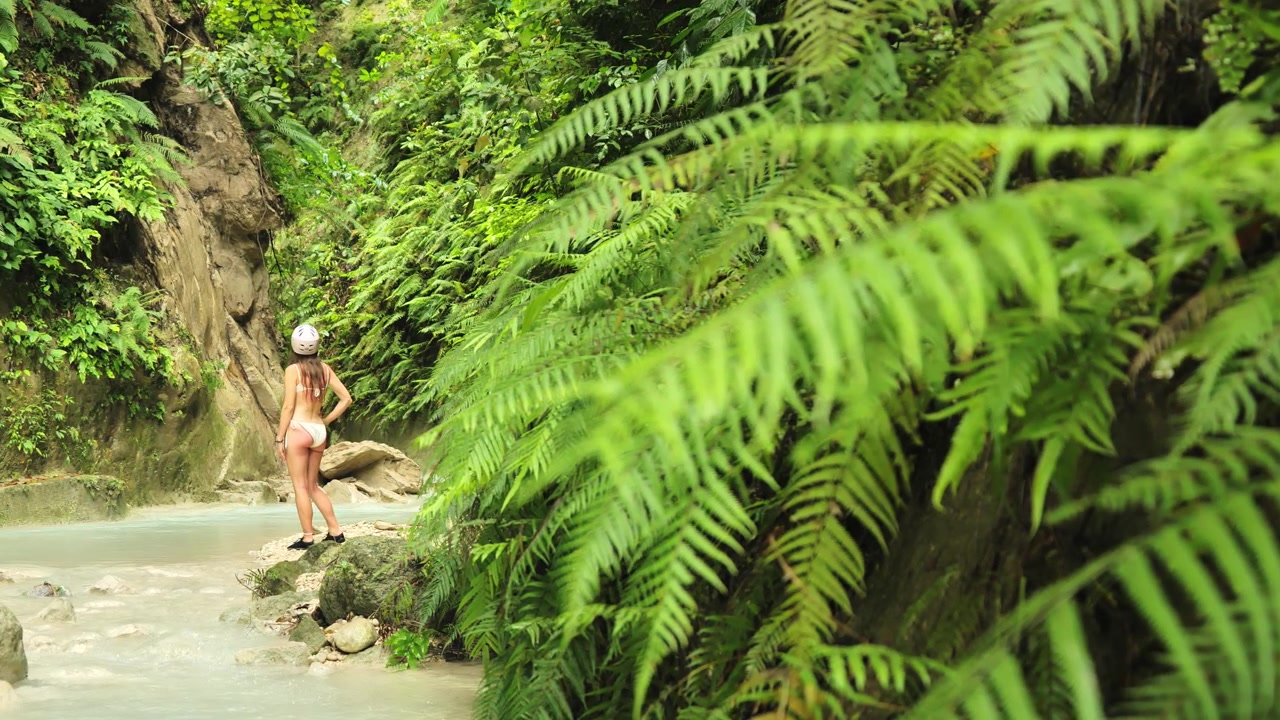 Turista pozorující útesy kaňonu u vodopádů Dao, Samboan, Cebu, Filipíny