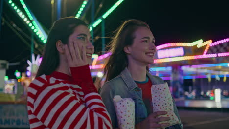 teenagers enjoying amusement park weekend closeup. smiling two friends walking