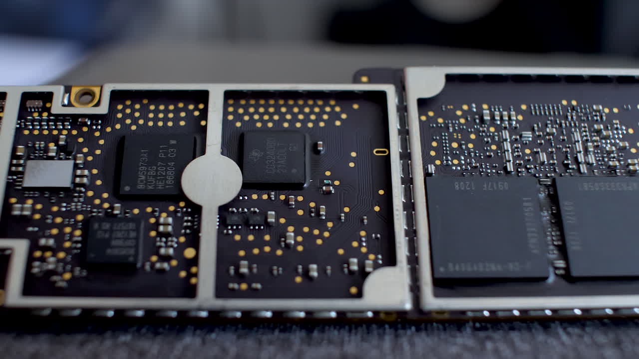 una vista detallada de una placa base de tableta con varios circuitos integrados y conectores, centrada en el área central