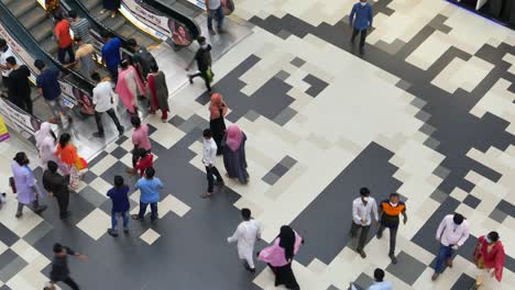 busy mall interior with escalators and people