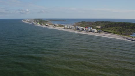 aerial flight from the gulf coast towards beach front homes along a florida peninsula