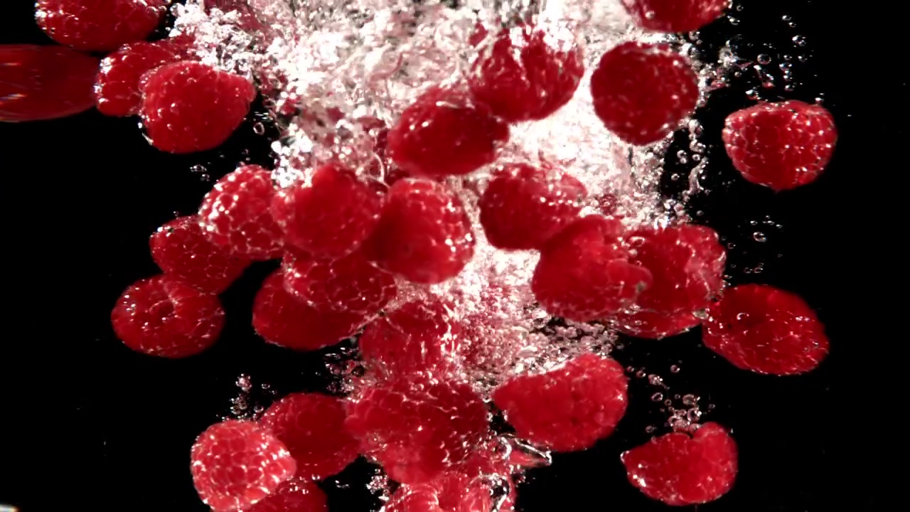 Slow Motion of Red Raspberries Dropping into Water with Bubbles