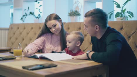 una familia feliz se sienta en un sofá de cuero marrón en una mesa de madera