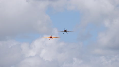 two acrobatic light aircrafts flying together towards the camera