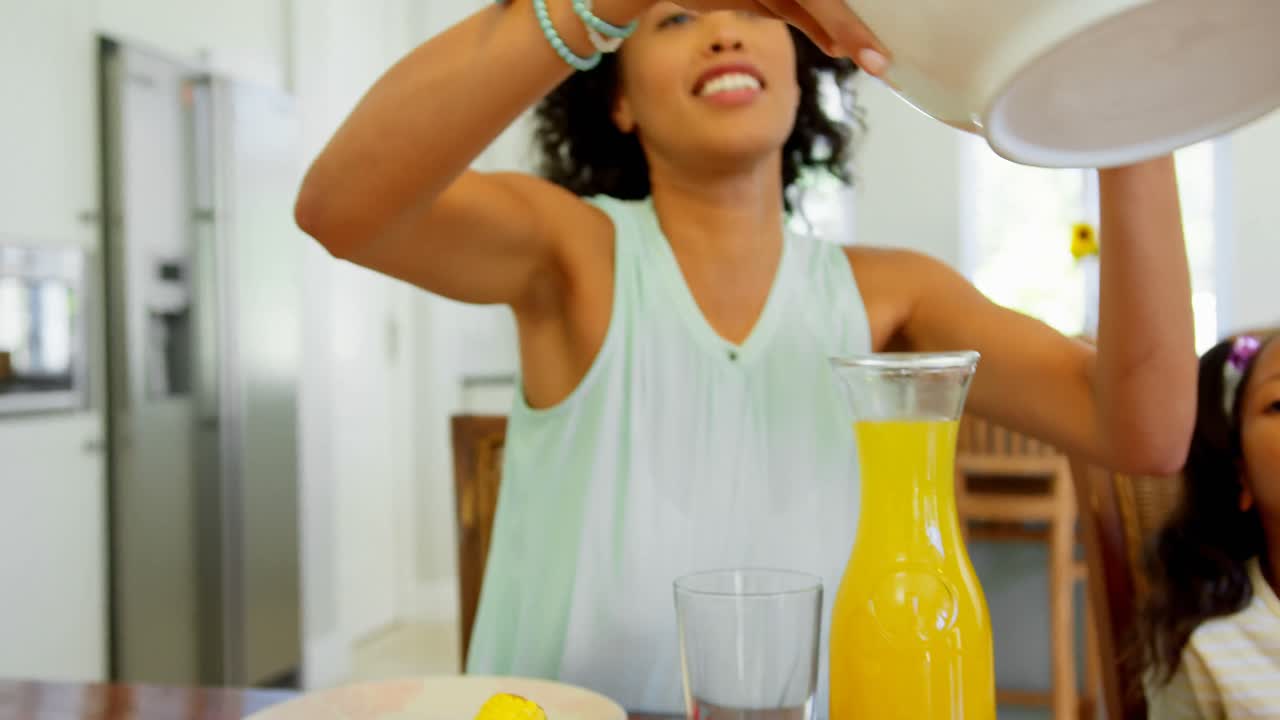 Black family eating food on dining table at home 4k