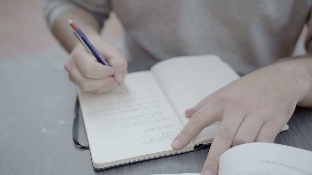 A male student taking notes by hand