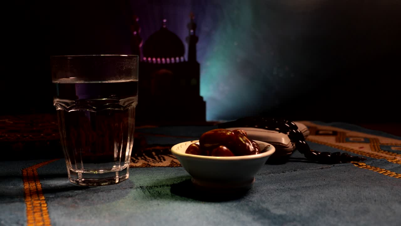 agua y dátiles. el iftar es la comida de la noche. vista deslizante de la decoración vacaciones de ramadán kareem. tarjeta de felicitación festiva, invitación para el mes sagrado musulmán ramadán kareem. fondo oscuro. enfoque selectivo