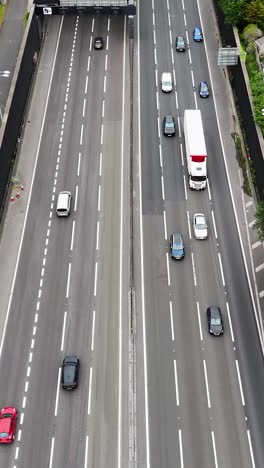 Portrait Drone flight over M25 motorway and Tunnel with signs to A10, Enfield and London