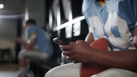 football player on phone in locker room