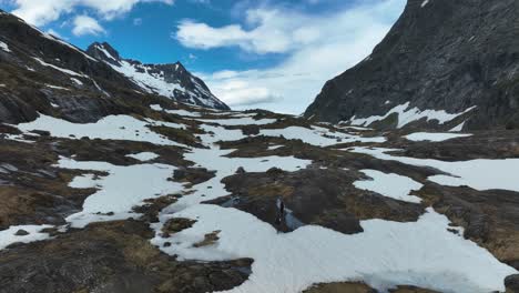 Excursionistas-Caminando-Por-Un-Terreno-Montañoso-Nevado-Con-Un-Impresionante-Cielo-Azul-En-Noruega