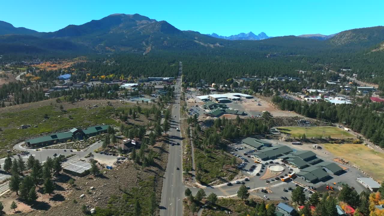 Old Main Street Mammoth Mountain Lakes Ski Area Sierras aerial drone California summer autumn fall Aspen Trees sunny blue sky Inyo National Forest downtown Main Lodge McCoy Station forward pan up