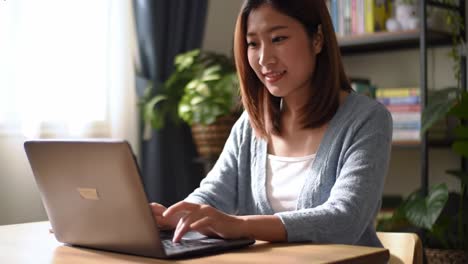 a young woman engaged in focused work on her laptop in a cozy, well-lit home office, illustrating creativity and concentration in the modern workspace