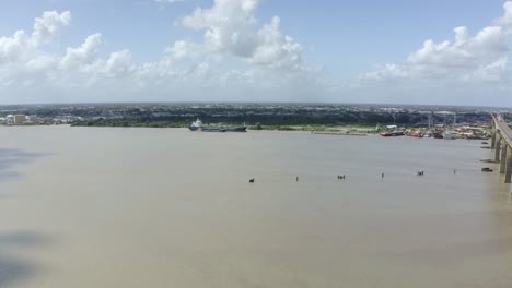 Vista-De-Drones-Acercándose-Al-Buque-Petrolero,-Puente-Jules-Wijdenbosch-Cerca-Del-Paso-Elevado