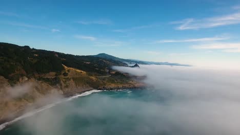 aerial: high above a foggy oregon ocean, our drone pushes towards the coastline