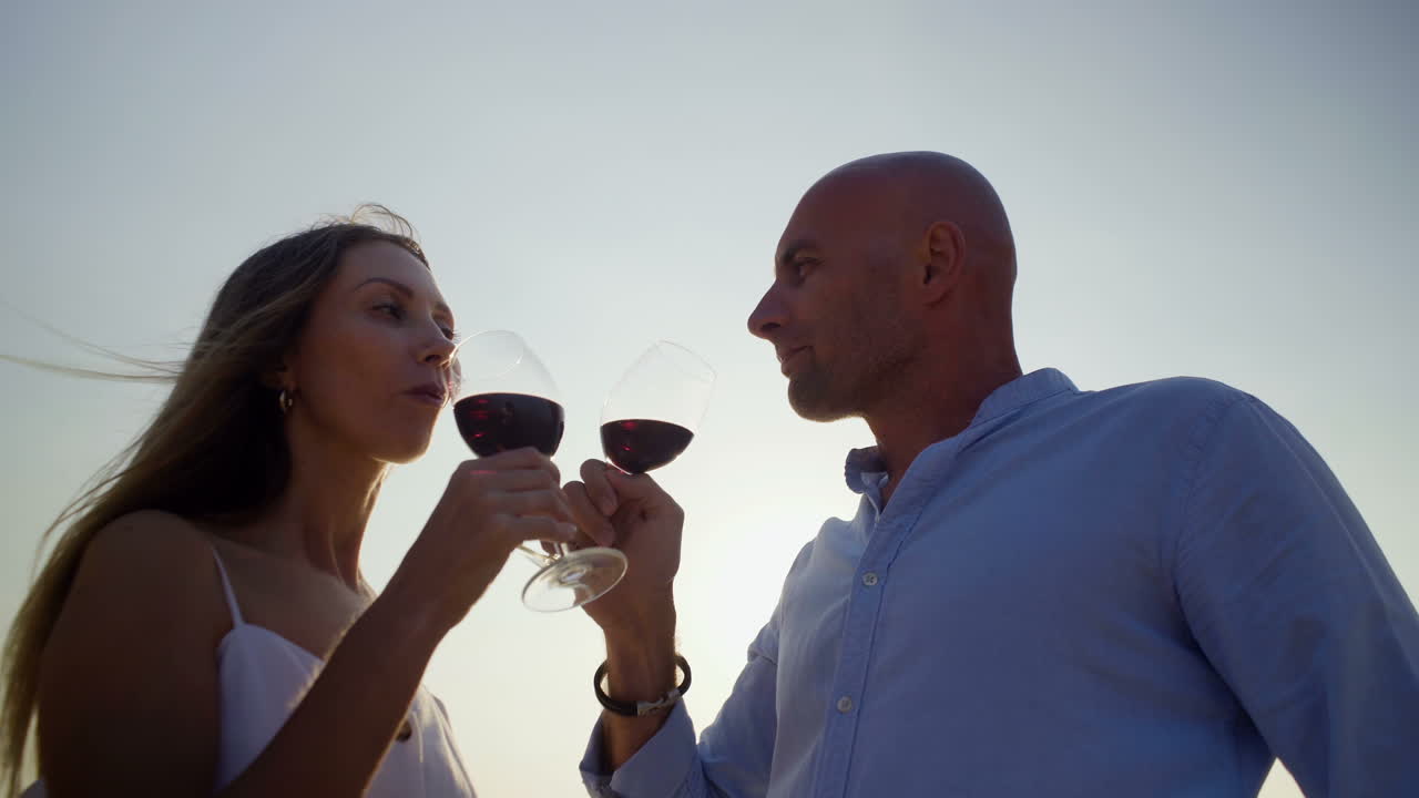 Couple drinking red wine at sunset