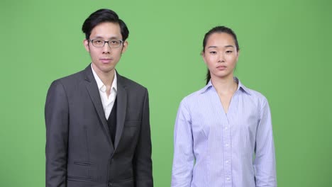 young asian business couple giving handshake together