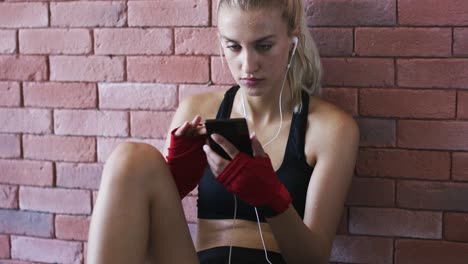 sportswoman listening to music and using smartphone