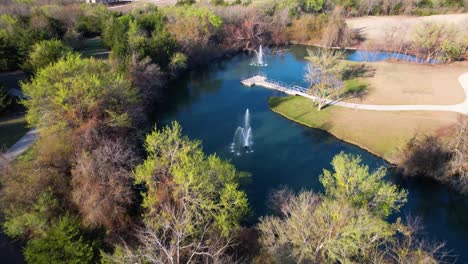 pond in natural springs park in anna texas with 2 fountains