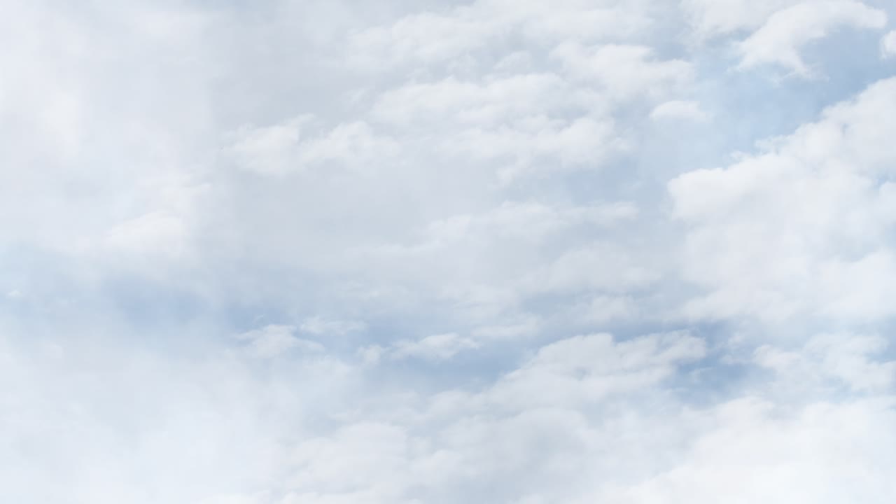 푸른 하늘을 가로질러 이동하는 흰 구름 확대