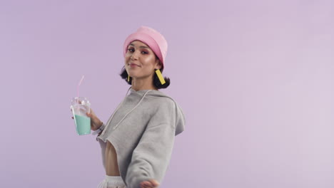 una mujer joven bailando mientras sostiene un batido de leche