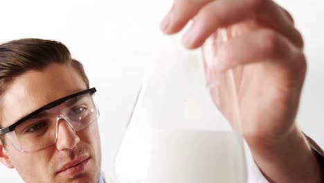 scientist examine solution in flask