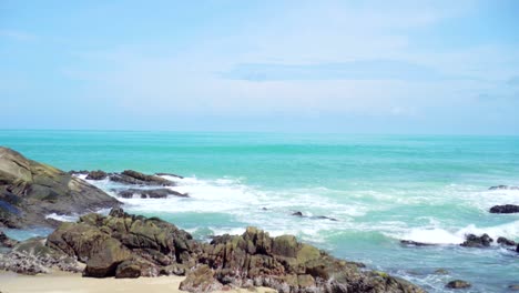 tropical beach wave and sand and rocks.