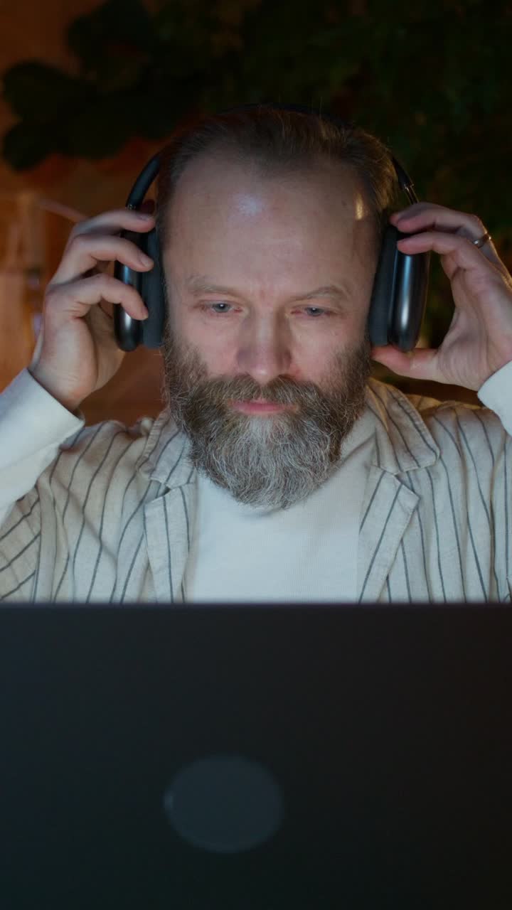 hombre trabajando en una computadora portátil con auriculares