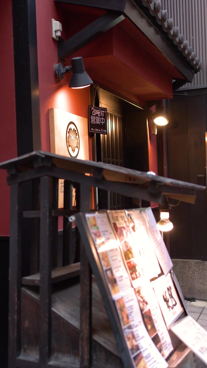 Et kamera panorerer fra et glødende barvindu til en menyplakat i Kyoto, Japan