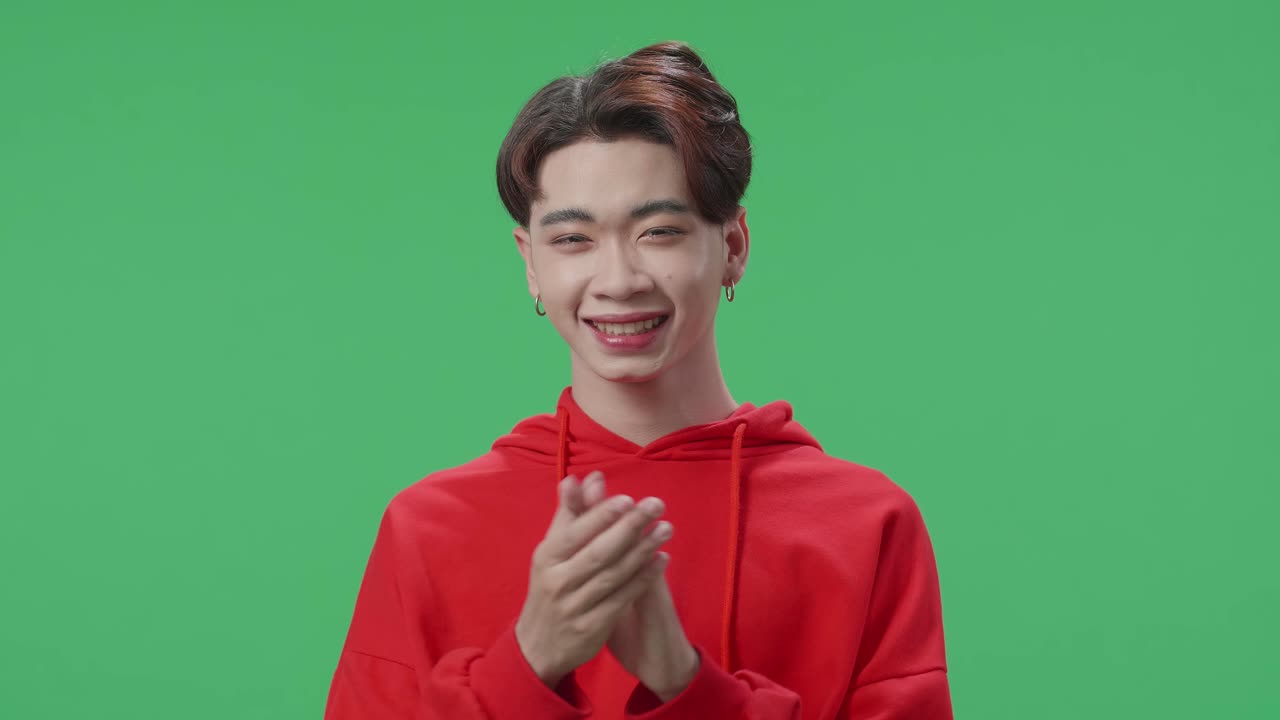 Young Asian Transgender Male Clapping Her Hands And Emotionally Flipping Something In The Green Screen Studio