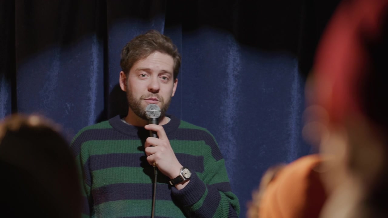 Komedian Berbicara di Mikrofon dan Bertepuk Tangan Selama Pertunjukan Stand-up