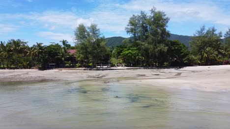 AERIAL:-Panning-left-to-right-above-a-Сoastline-with-mountains-on-the-background-on-Koh-Chang-in-Thailand,-Asia