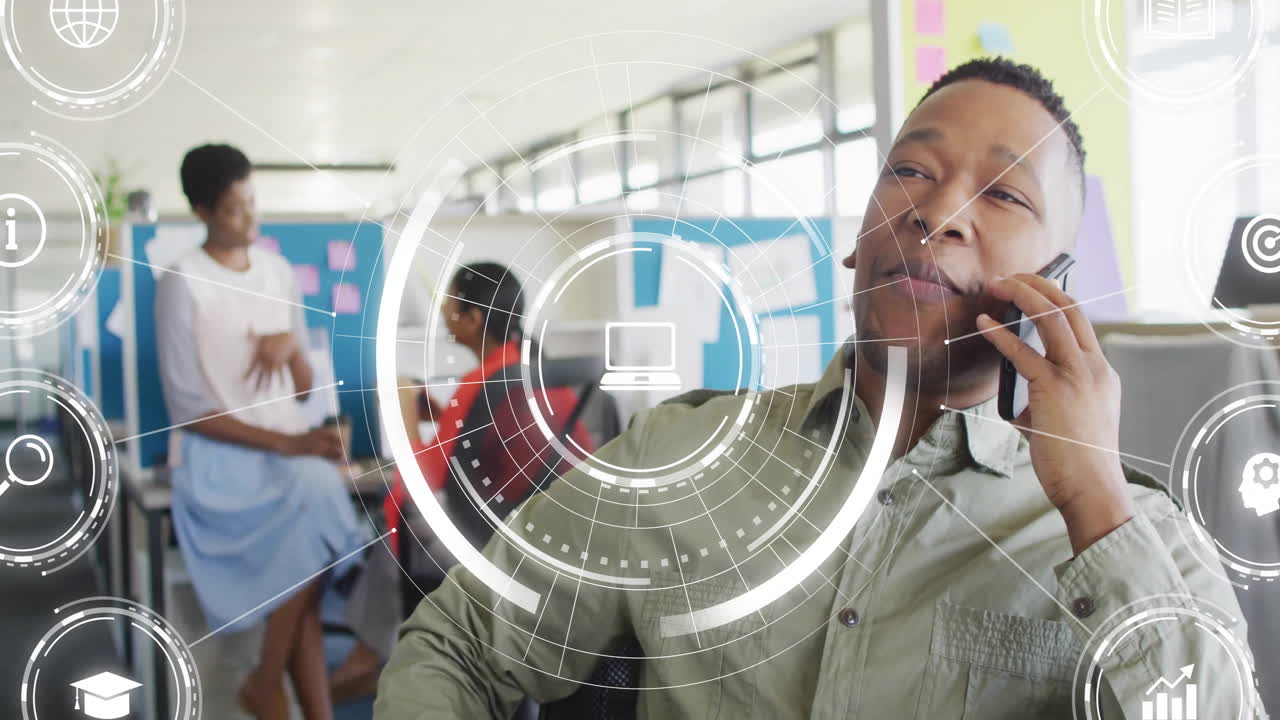 Animation of media icons over diverse colleagues discussing work and talking on smartphone in office