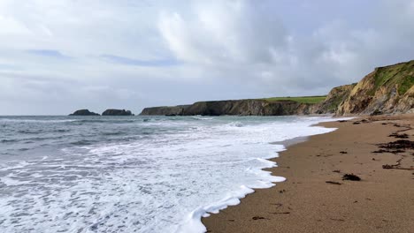 Flut-Und-Wellen-Brechen-Sich-An-Einsamen-Sandstränden-In-Waterford,-Irland-An-Einem-Frühlingsmorgen