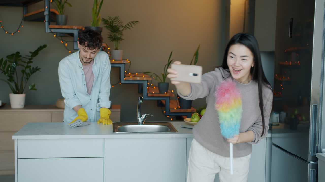 Couple Cleaning Kitchen and Taking Selfie