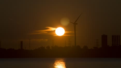 gran amanecer naranja que se levanta detrás del molino de viento