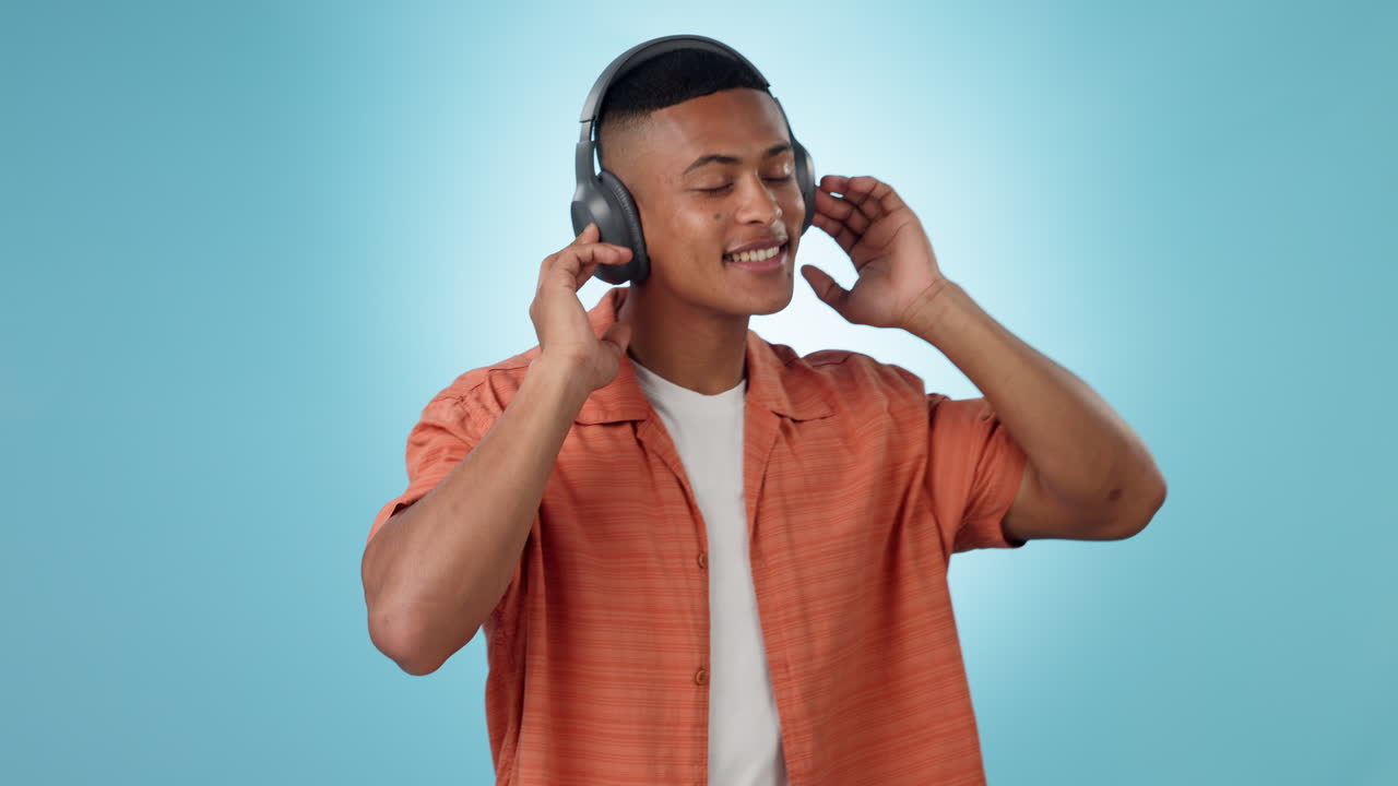 Headphones, dancing and young man in a studio