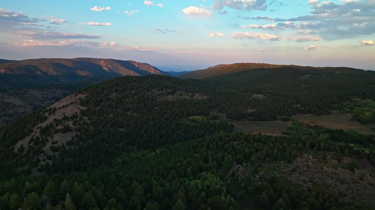 Golden hour aerial view of a mountainous landscape with fading light creating soft shadows over the hills, Boulder colorado