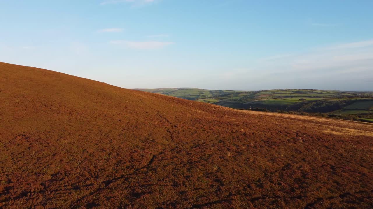 황무지의 빠른 일몰 공중 드론 영상은 북부 데번 영국 4k의 구불구불한 푸른 언덕을 드러냅니다.